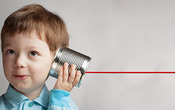 happy boy plays with tin can phone